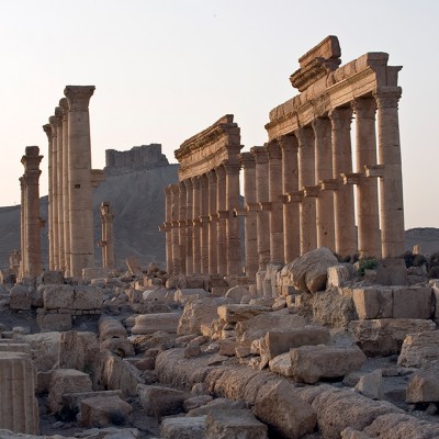 La grande colonnade traversait la partie officielle de Palmyre. De part et d'autre s'élevaient les thermes monumentaux. La perspective est fermée par un temple funéraire resté anonyme. Au fond, le château arabe semble veiller sur l'oasis.
