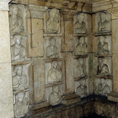 Hypogée d’Iahrai (108 apr.J.-C. - Palmyre). Hypogée remonté au musée de Damas. Le défunt, entouré de sa famille, est étendu sur la kLinè (lit ou canapé utilisé dans la Grèce ancienne pour dîner) et porte la haute coiffure typique des prêtres de Bêl.