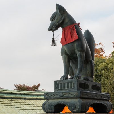 Le temple Fushimi Inari-taisha. Les statues de renards tiennent un objet symbolique dans la gueule ou sous une patte avant - le plus souvent un bijou et une clé, mais une gerbe de riz, un rouleau ou un renardeau sont monnaie courante.